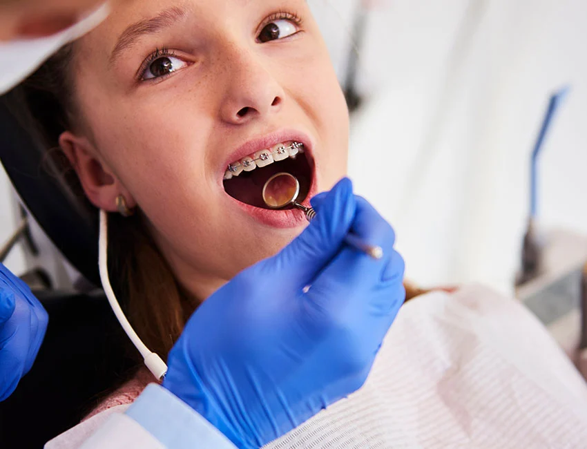 Orthodontist conducting early orthodontic evaluation for a child